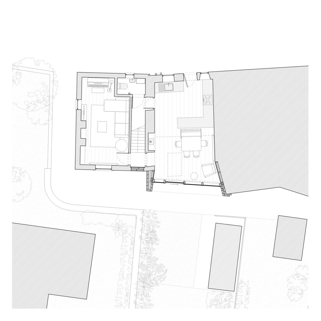 Floor plan showing a house layout with a living area, kitchen, dining space, and outdoor patio. Adjacent are garden areas and neighboring structures. Pathways and trees are indicated in the surrounding landscape.