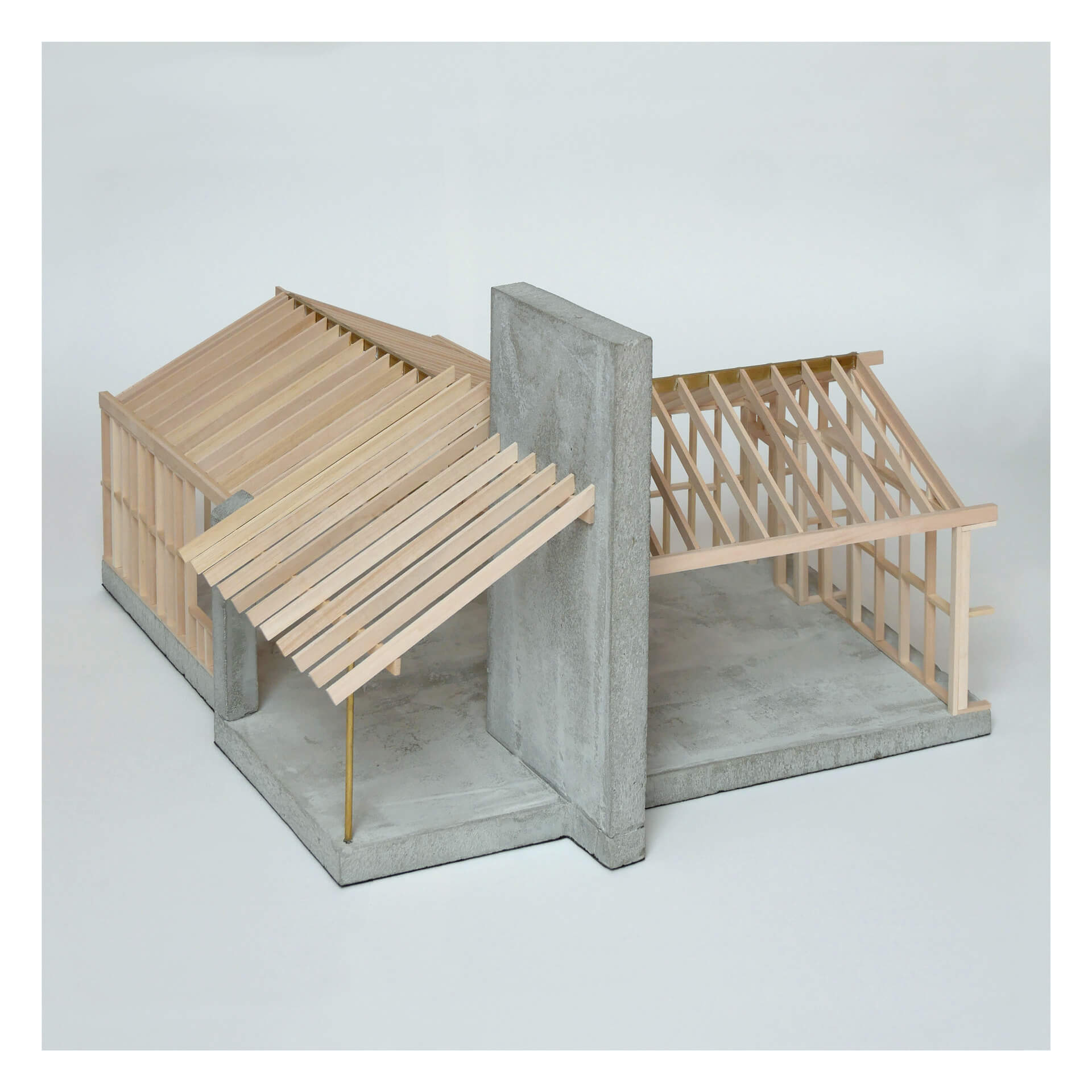 Model of a building structure featuring a gray concrete wall and wooden frame sections, including slanted roof panels. The design resembles an unfinished open-concept architectural layout.