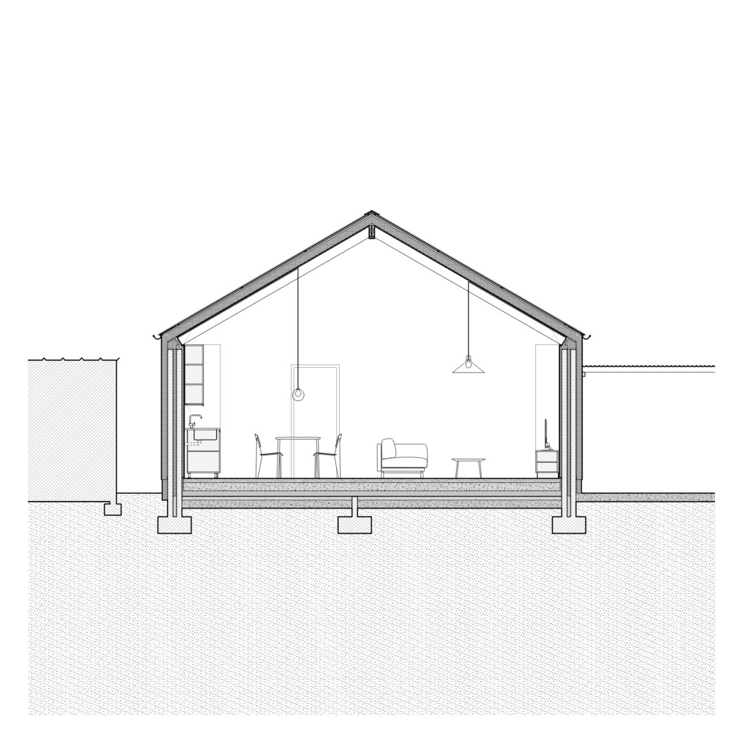 Cross-section illustration of a house showing the interior layout. Features include a pitched roof, living space with a sofa, a table and chairs, a hanging light fixture, a kitchen area, and structural details of the foundation and walls.